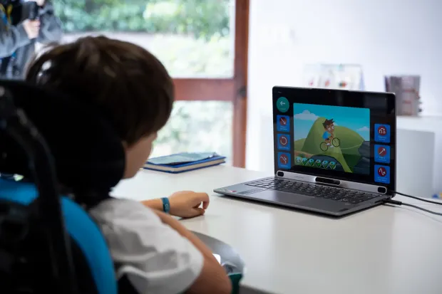 Jovem de costas a interagir com computador